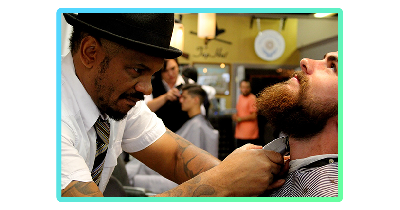 Man getting beard trimmed in barber shop